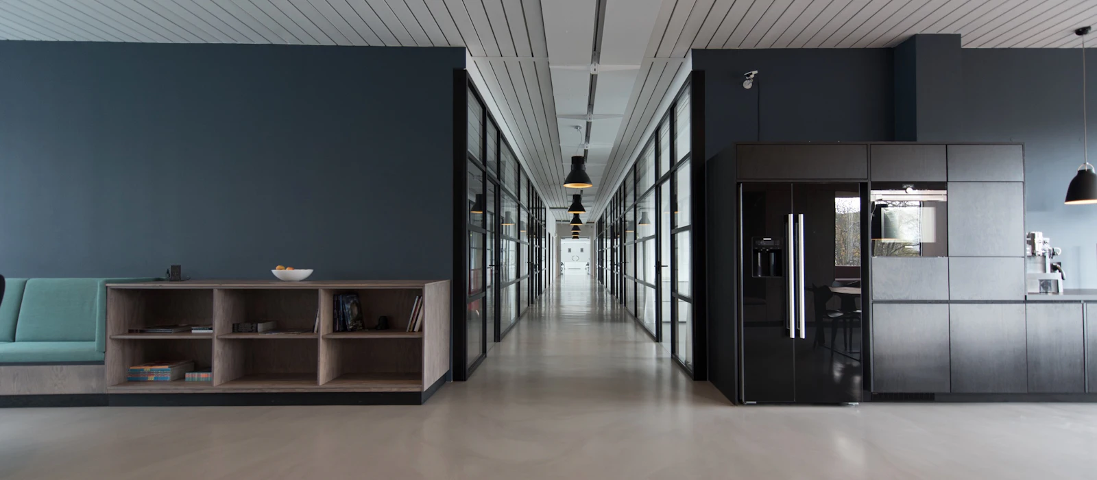 A bright modern office hallway with glass walls