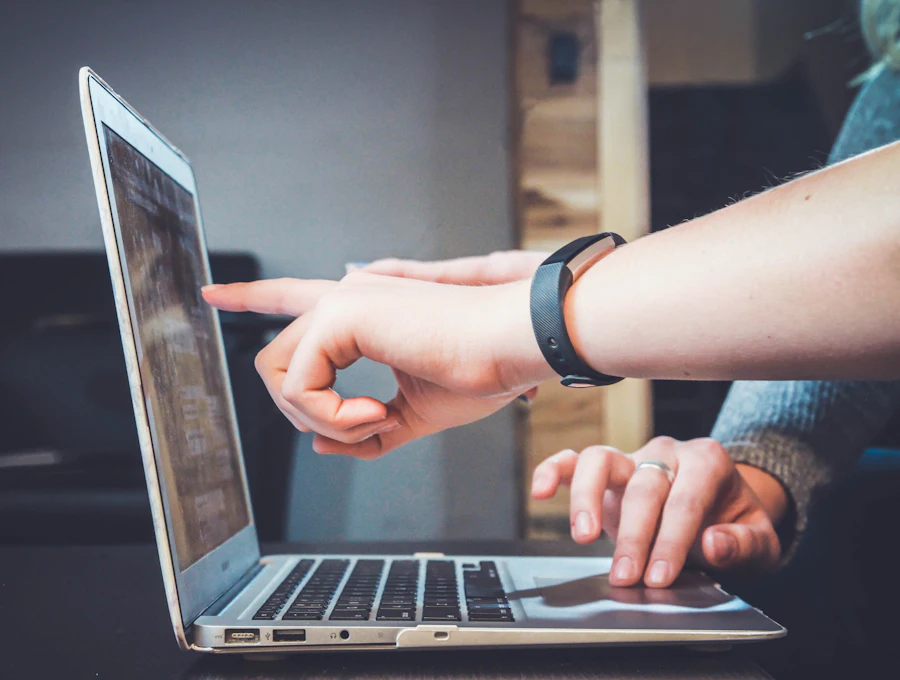 Two people reviewing files on a laptop