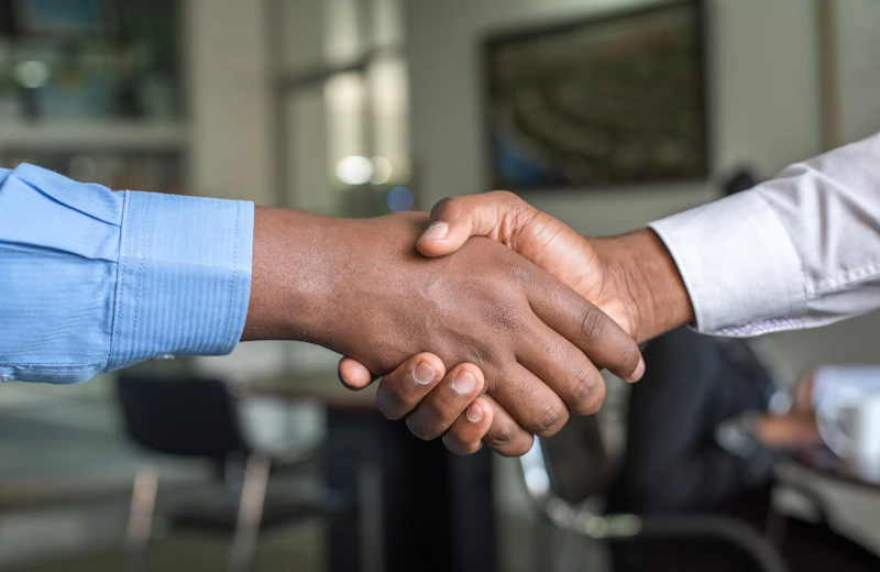 Dos profesionales dándose la mano tras una reunión